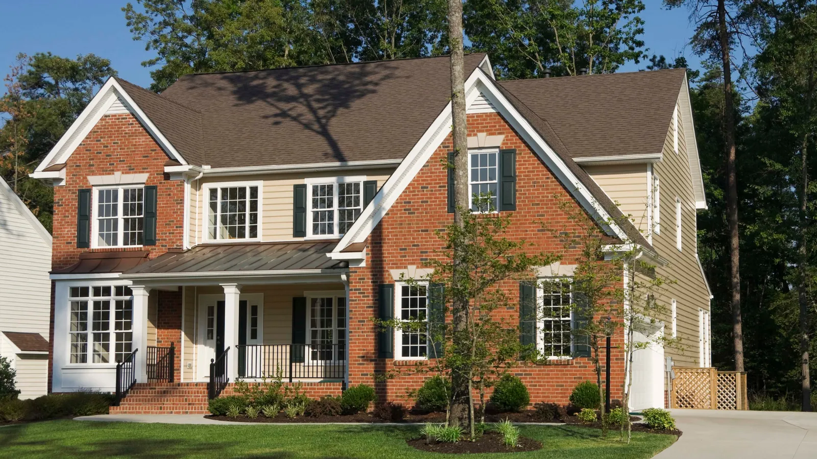 Red brick and siding two-story with a brown asphalt shingle roof