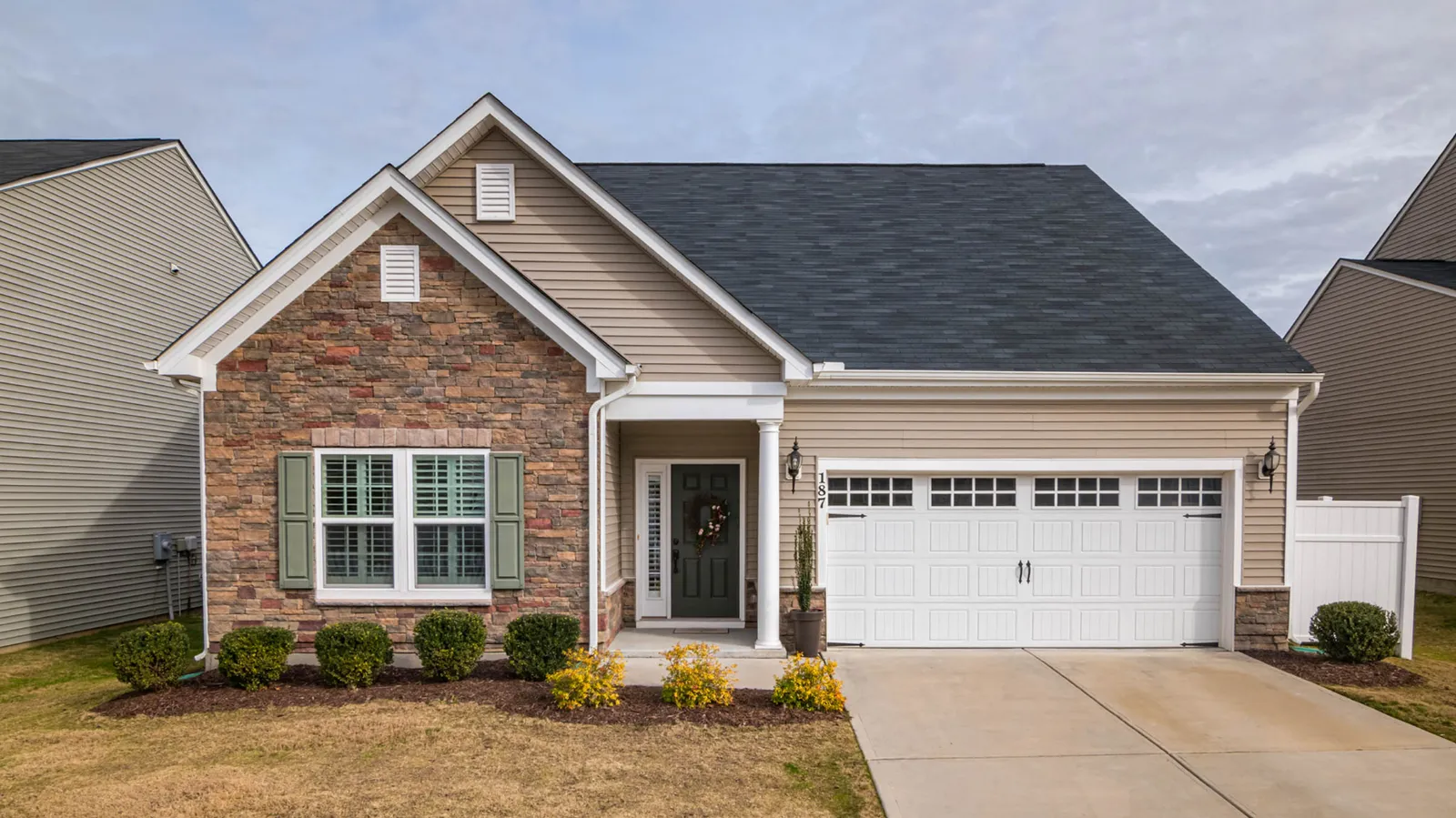 Dark gray asphalt shingle roof over a stone and siding ranch home